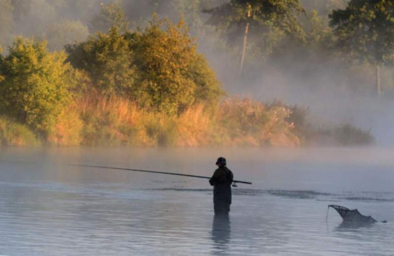 Un hombre pescando en la niebla.