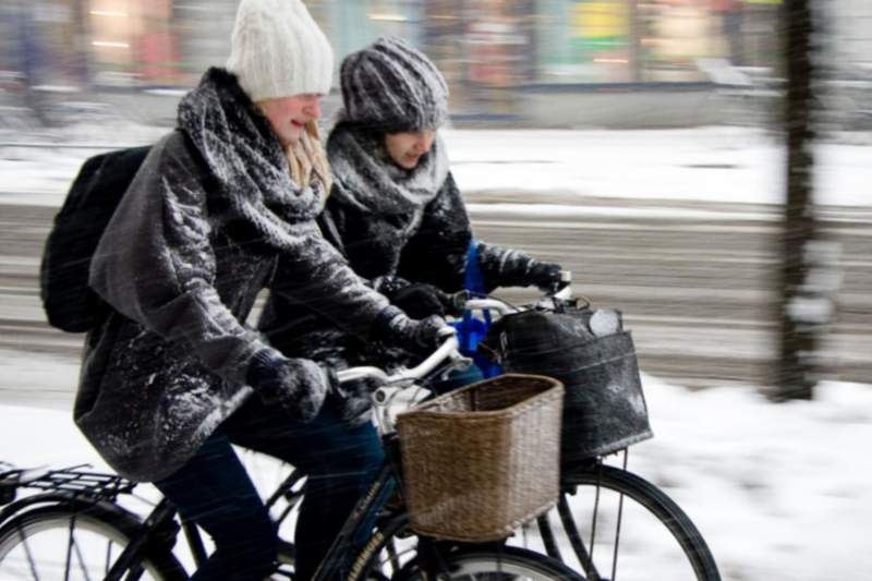 Les nenes van caure sota la neu amb bicicletes.